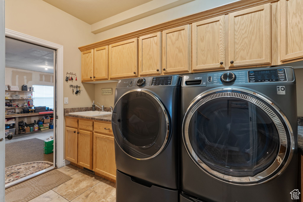 Laundry area with cabinet space and washing machine and clothes dryer