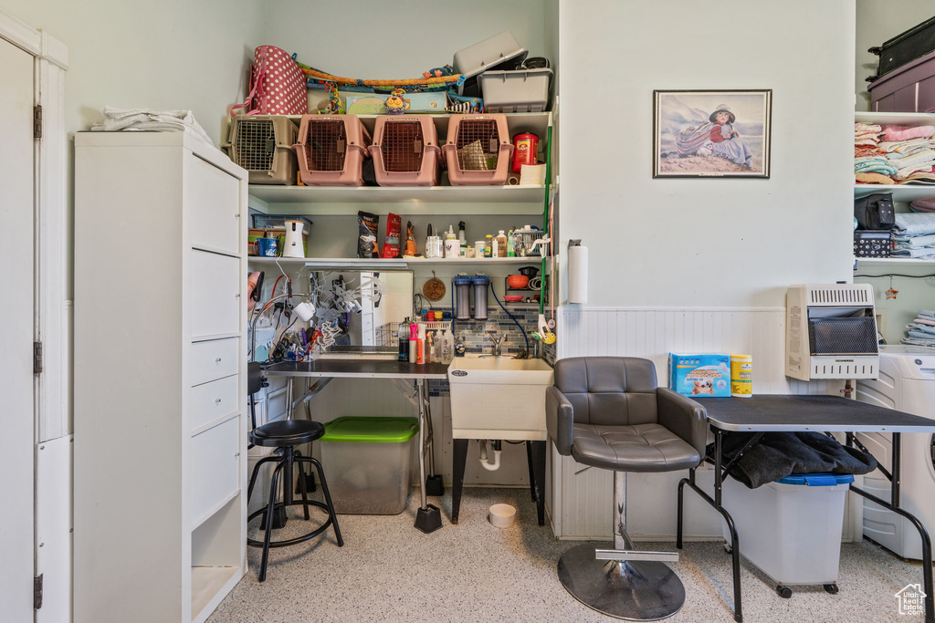 Home office featuring heating unit, wainscoting, and speckle patterned floor