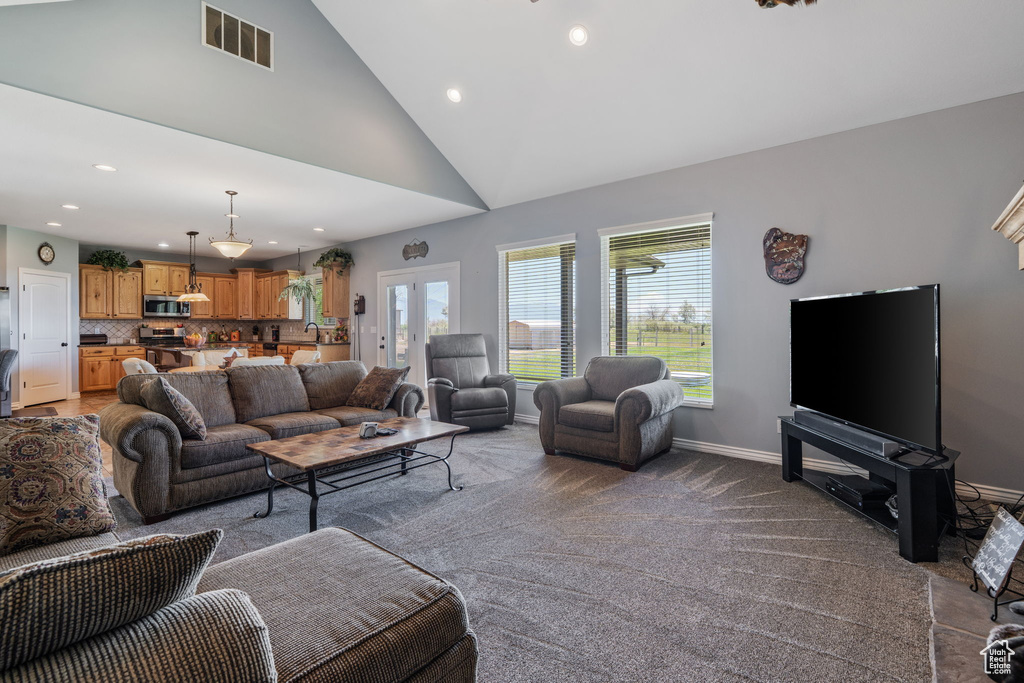 Living area with recessed lighting, vaulted ceiling, and light colored carpet
