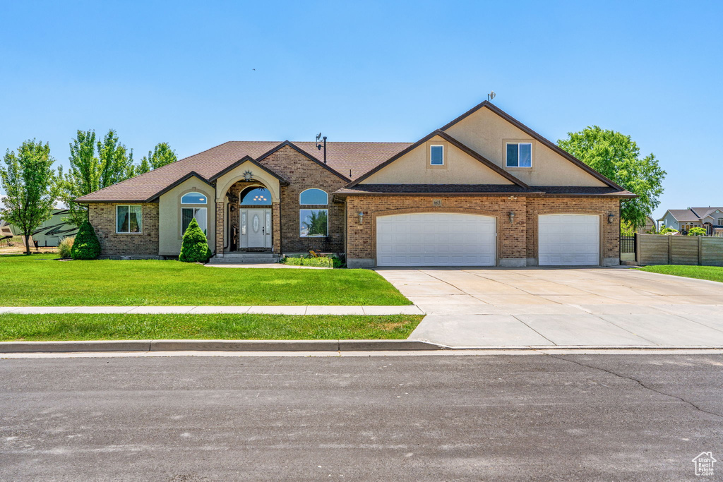 View of front of house featuring driveway, an attached garage, and brick siding