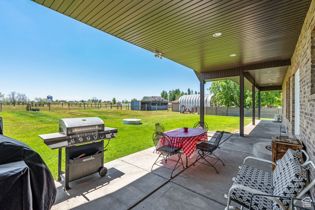 View of patio with outdoor dining area and grilling area