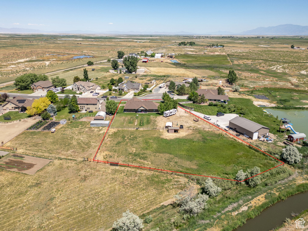Aerial view of sparsely populated area featuring property boundaries highlighted and a water and mountain view