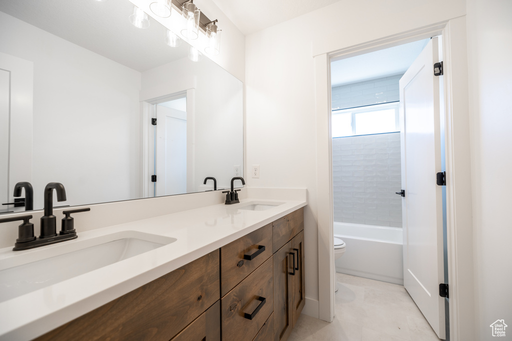 Bathroom featuring double vanity and shower / tub combination