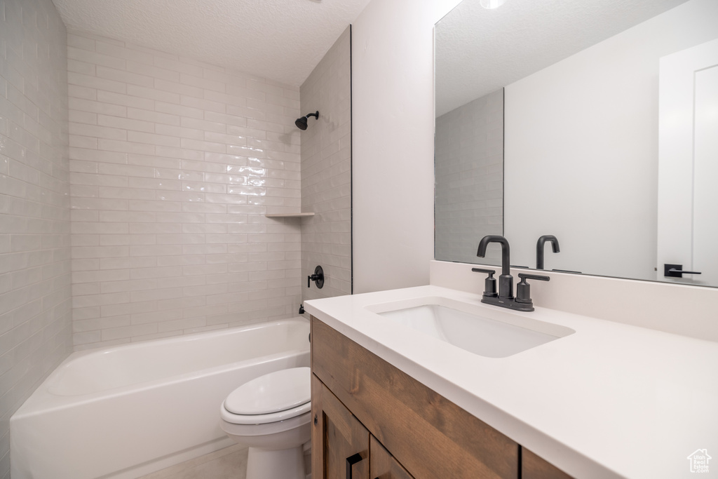 Bathroom with vanity,  shower combination, and a textured ceiling