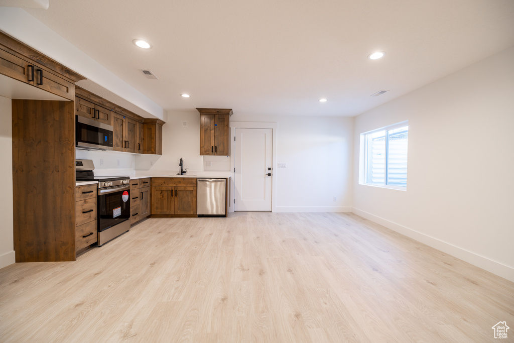 Kitchen featuring stainless steel appliances, recessed lighting, light countertops, and light wood-style floors
