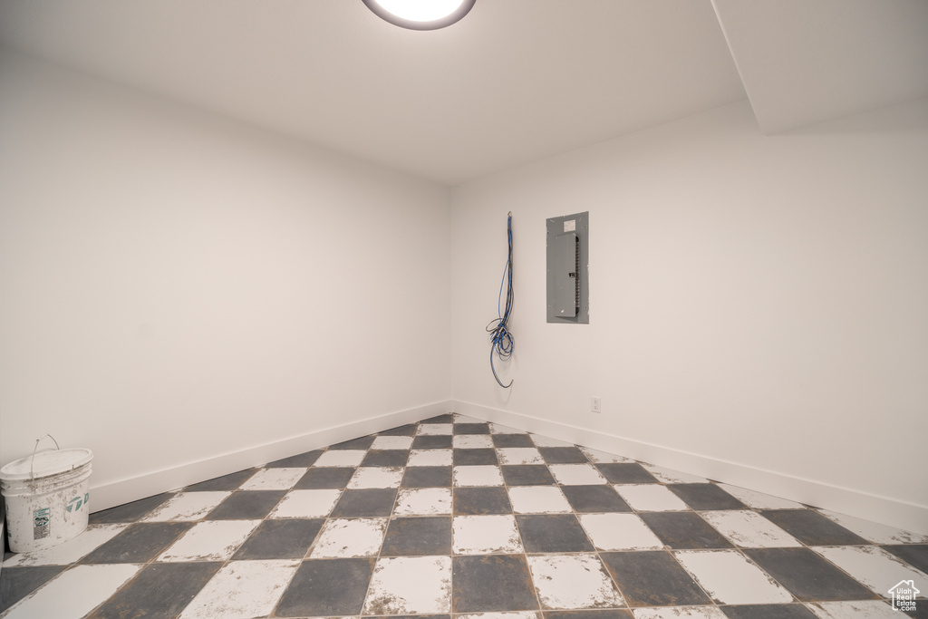 Empty room with electric panel and baseboards