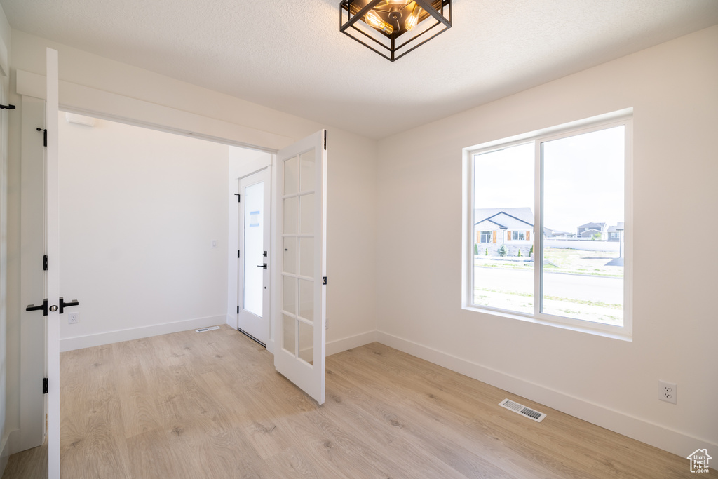 Spare room with light wood-style floors and french doors