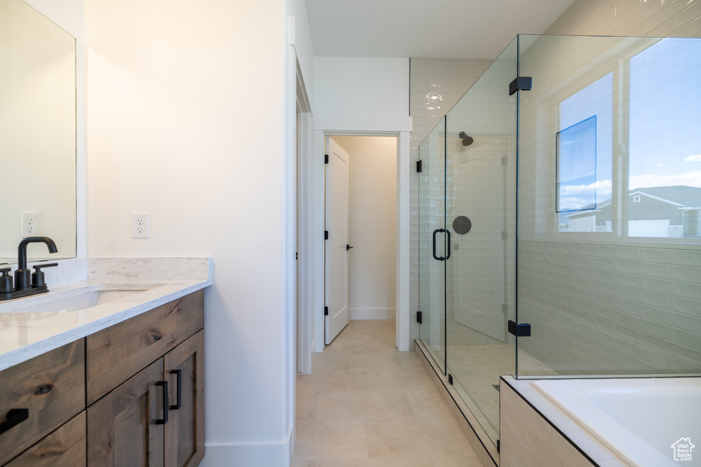 Full bathroom featuring vanity, a shower stall, and a bath