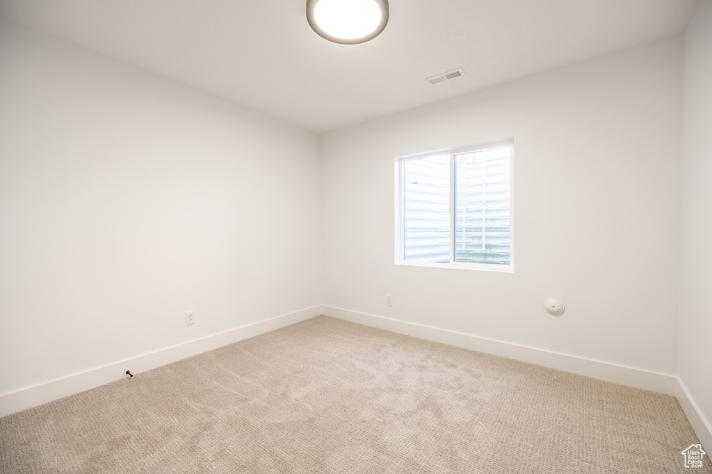 Spare room with light carpet and baseboards