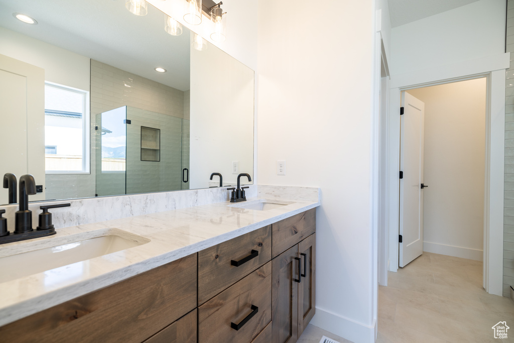Full bath with double vanity, a stall shower, and recessed lighting