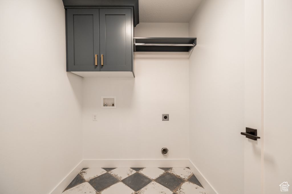 Laundry room with electric dryer hookup, hookup for a washing machine, and cabinet space