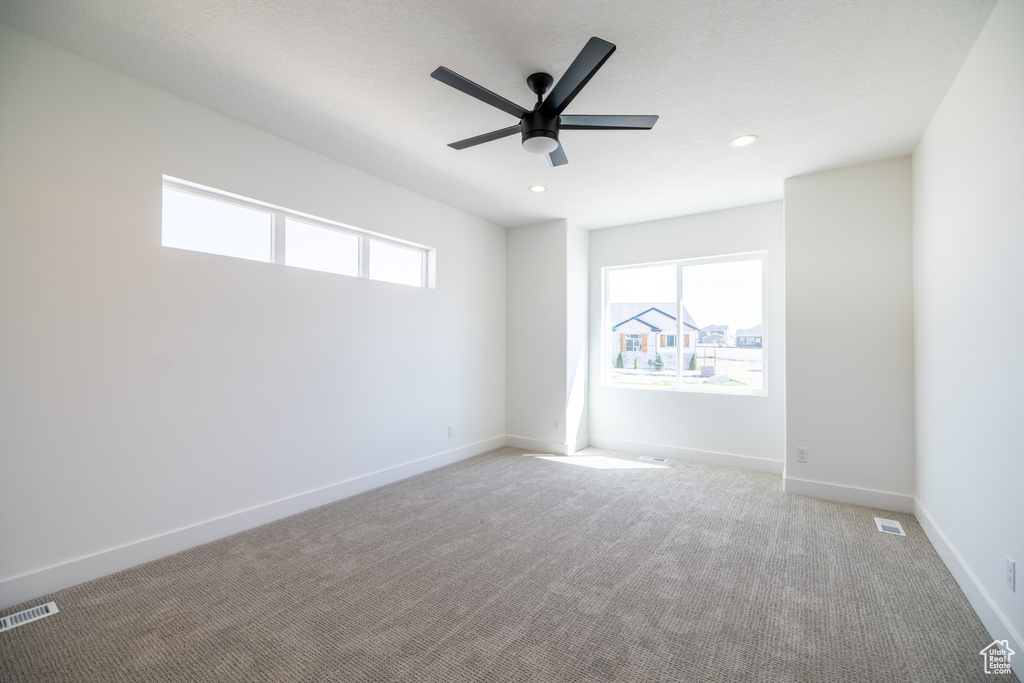 Empty room featuring a ceiling fan, light carpet, and recessed lighting