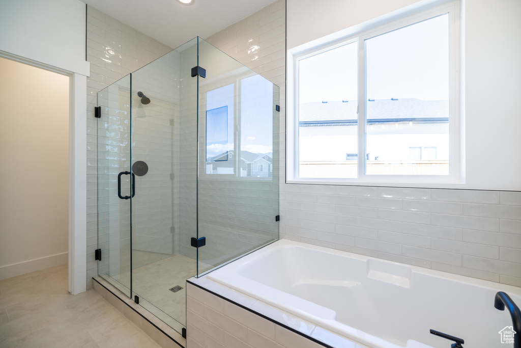 Bathroom with plenty of natural light, a bath, a shower stall, tile patterned floors, and recessed lighting