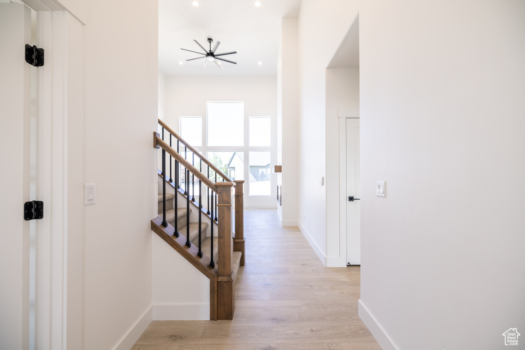 Hall featuring light wood finished floors, stairway, and recessed lighting
