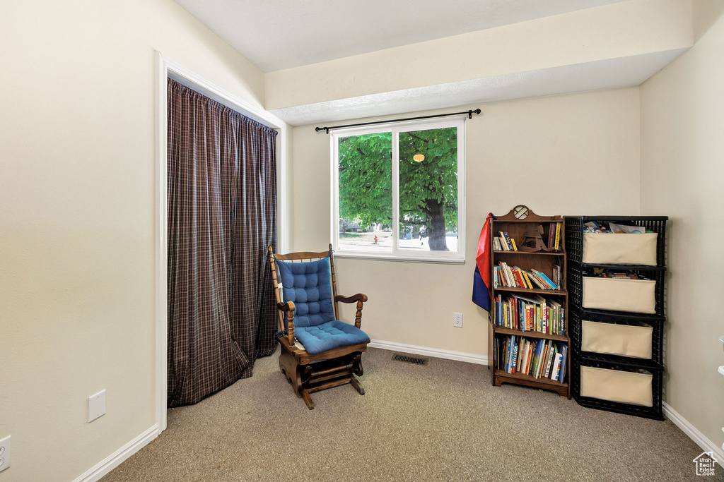 Sitting room featuring carpet flooring and baseboards