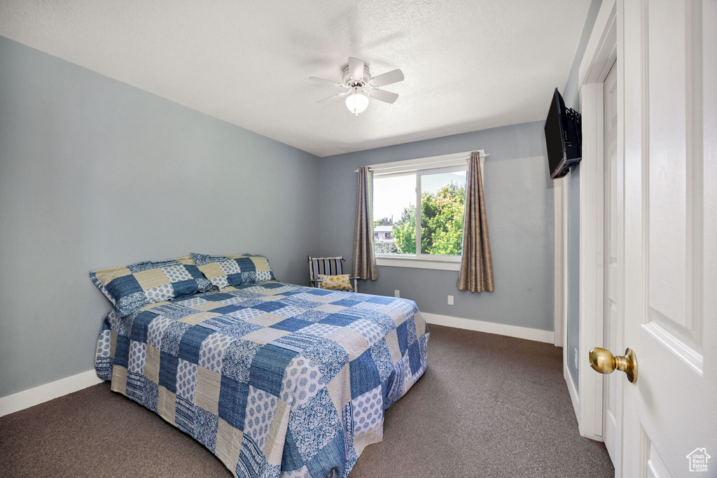 Carpeted bedroom featuring baseboards and a ceiling fan