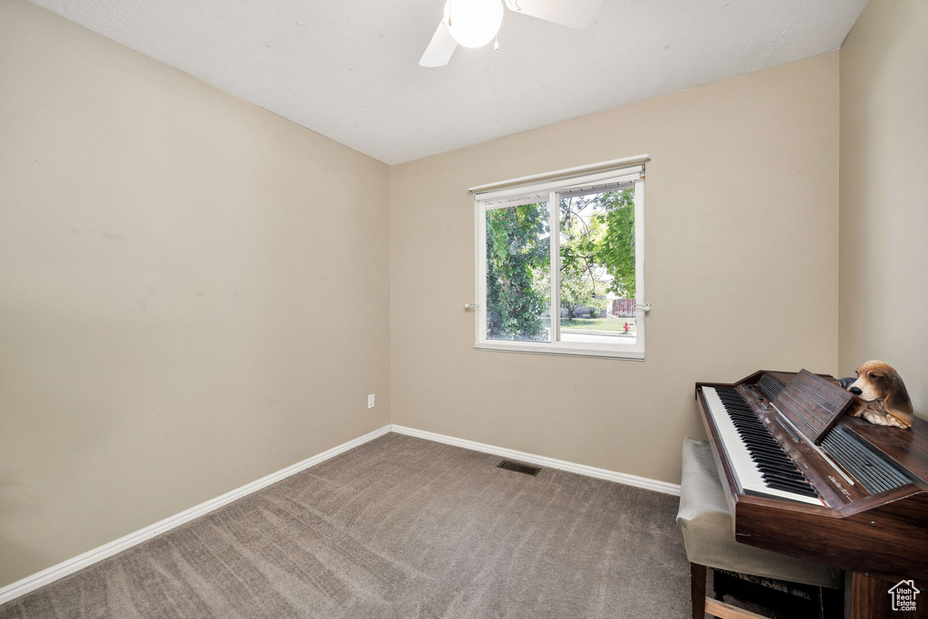 Unfurnished room featuring carpet floors and a ceiling fan