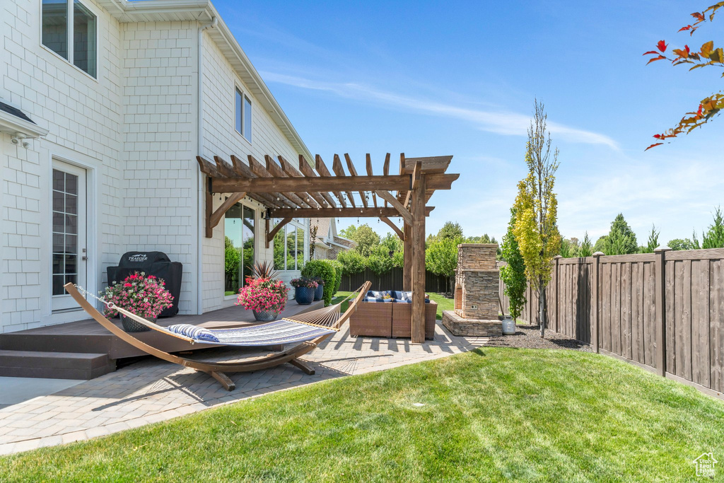 Fenced backyard with a patio, a pergola, and an outdoor living space with a fireplace