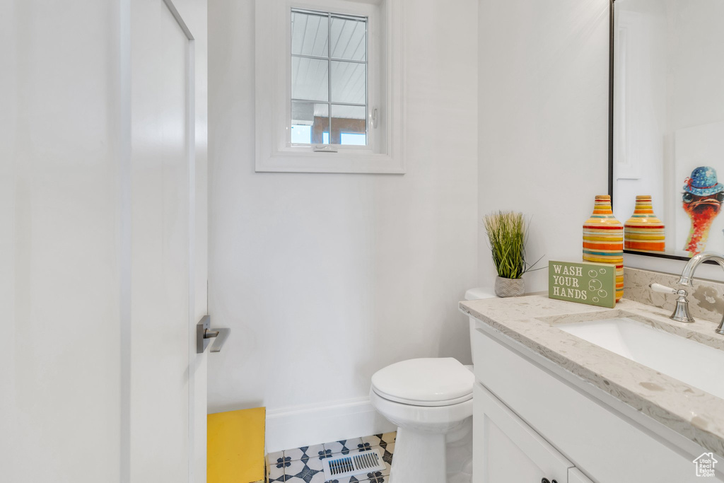 Half bathroom featuring vanity and tile patterned floors