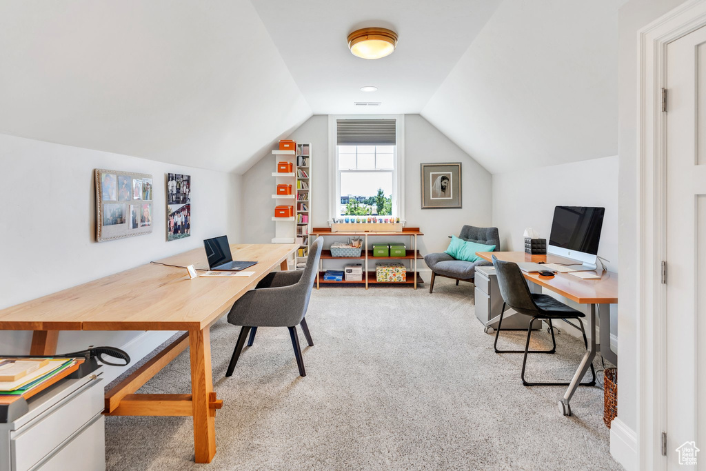 Carpeted office with lofted ceiling
