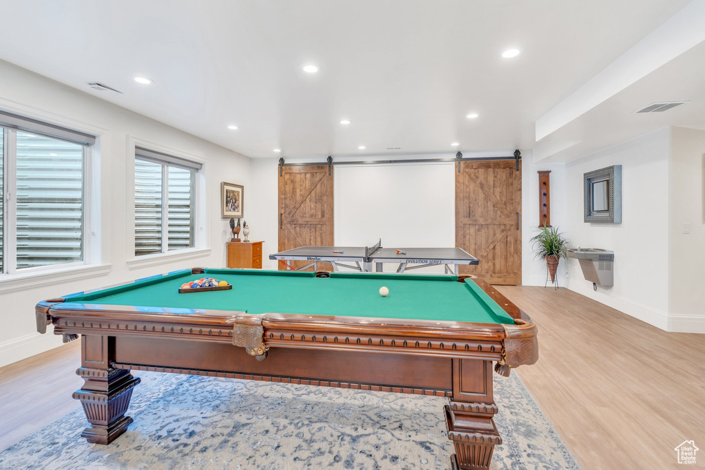 Recreation room with a barn door, wood finished floors, recessed lighting, and pool table