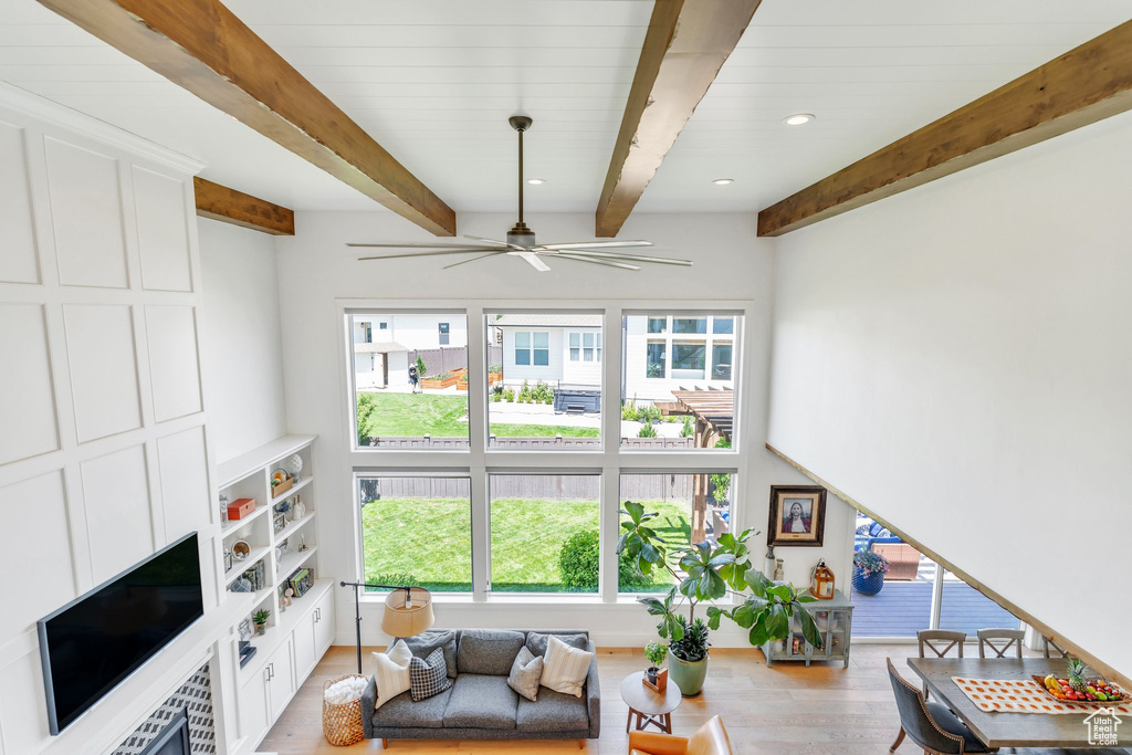 Living area featuring beam ceiling, a ceiling fan, light wood-style floors, and recessed lighting