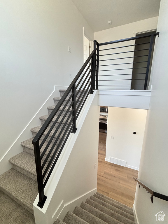 Stairway featuring wood finished floors and baseboards