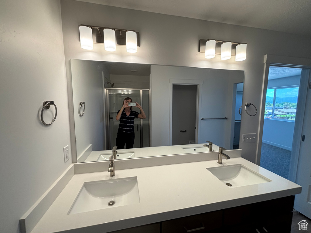 Full bath with a shower stall and double vanity