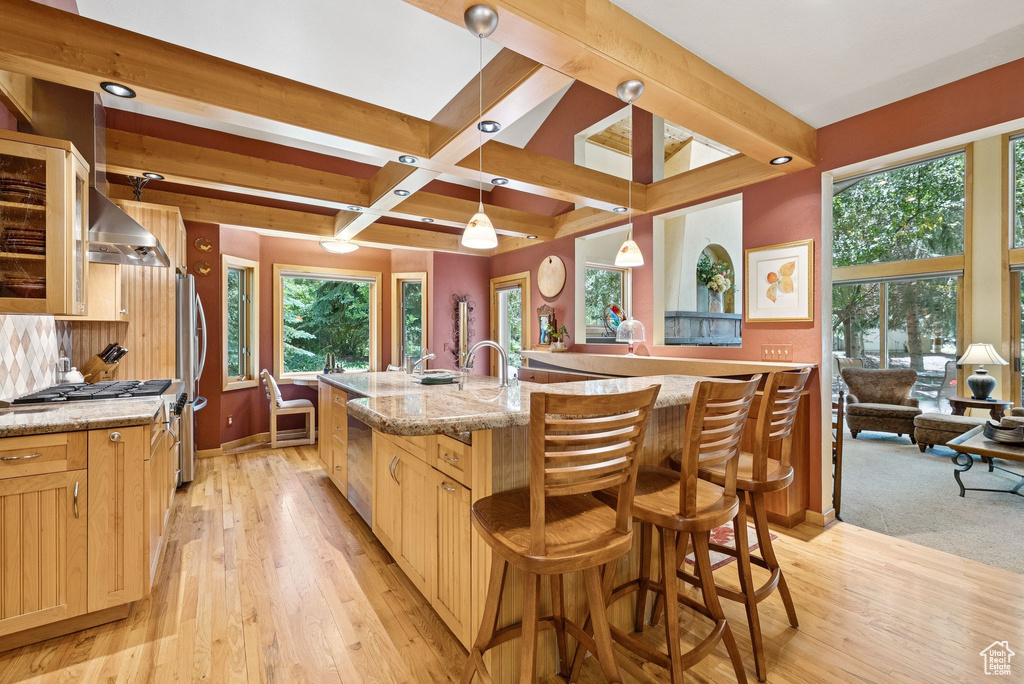 Kitchen with light brown cabinets, light wood finished floors, plenty of natural light, beam ceiling, and recessed lighting