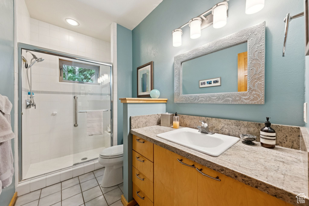 Full bathroom with vanity, a shower stall, and tile patterned floors