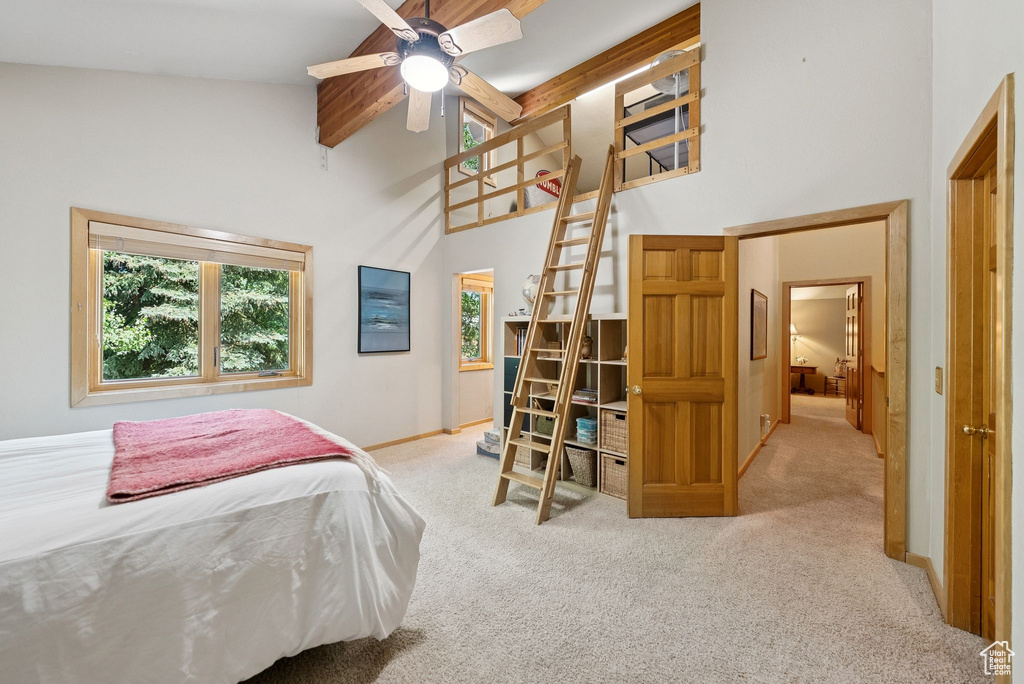Bedroom featuring high vaulted ceiling, multiple windows, carpet floors, and beamed ceiling