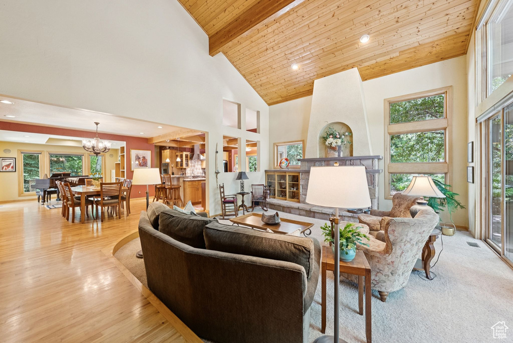 Living room featuring a wooden ceiling with exposed beams, a chandelier, high vaulted ceiling, light wood-style floors, and recessed lighting