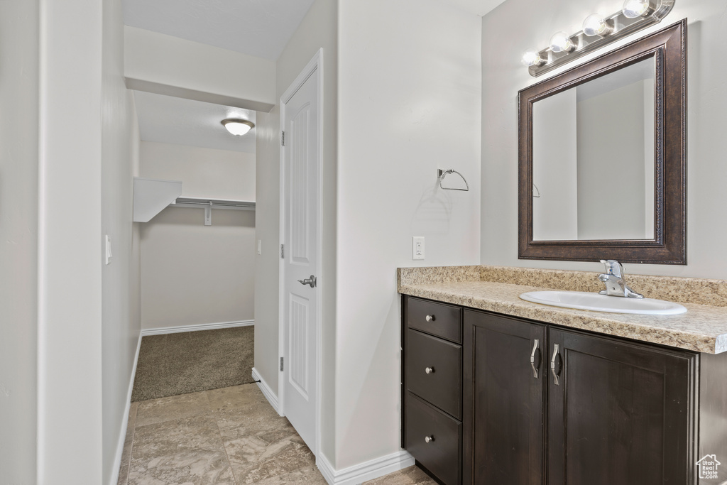 Bathroom with vanity and a walk in closet
