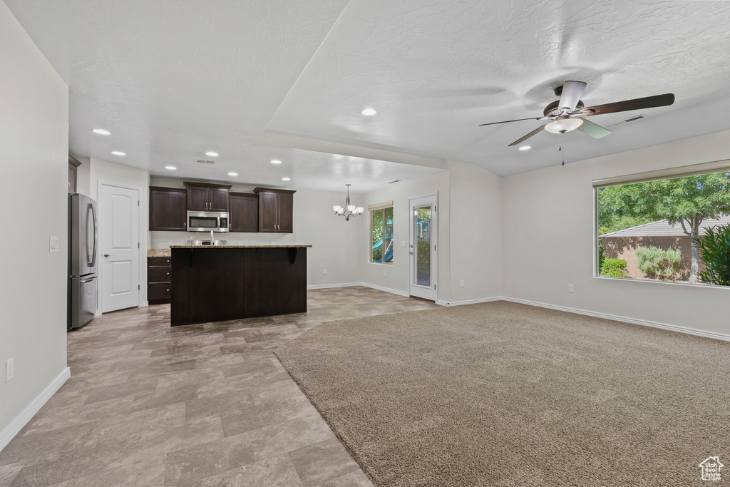 Unfurnished living room featuring a chandelier, recessed lighting, and a ceiling fan