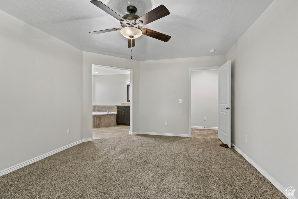 Unfurnished room featuring ceiling fan and light carpet