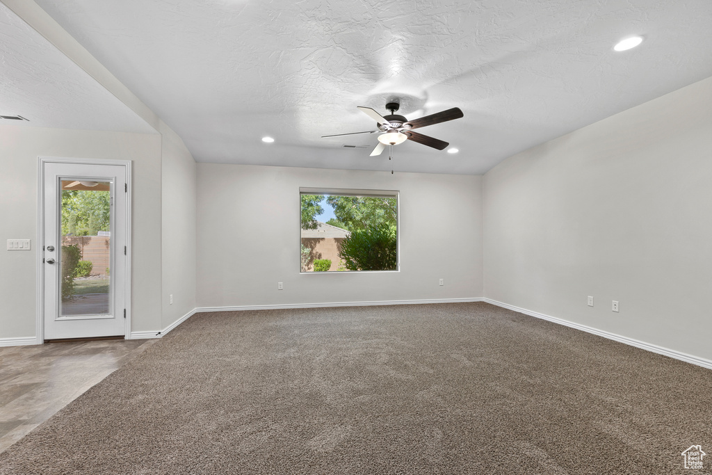 Empty room with healthy amount of natural light, a ceiling fan, recessed lighting, and carpet