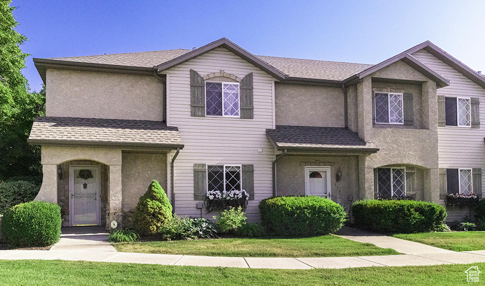 View of front of house featuring stucco siding and a shingled roof