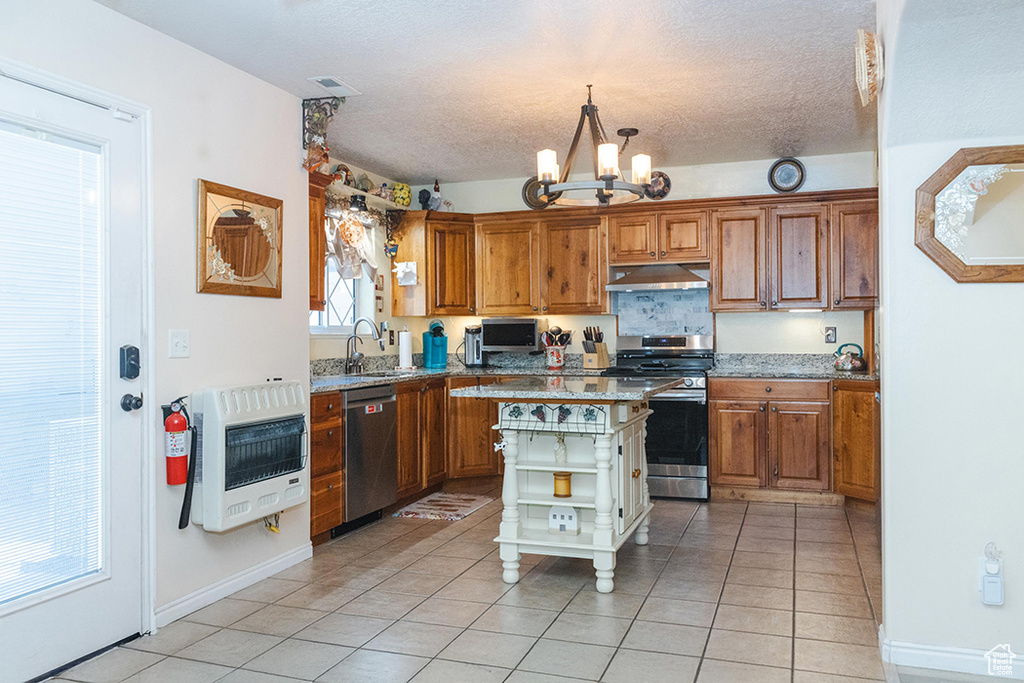 Kitchen with stainless steel appliances, under cabinet range hood, heating unit, a chandelier, and open shelves