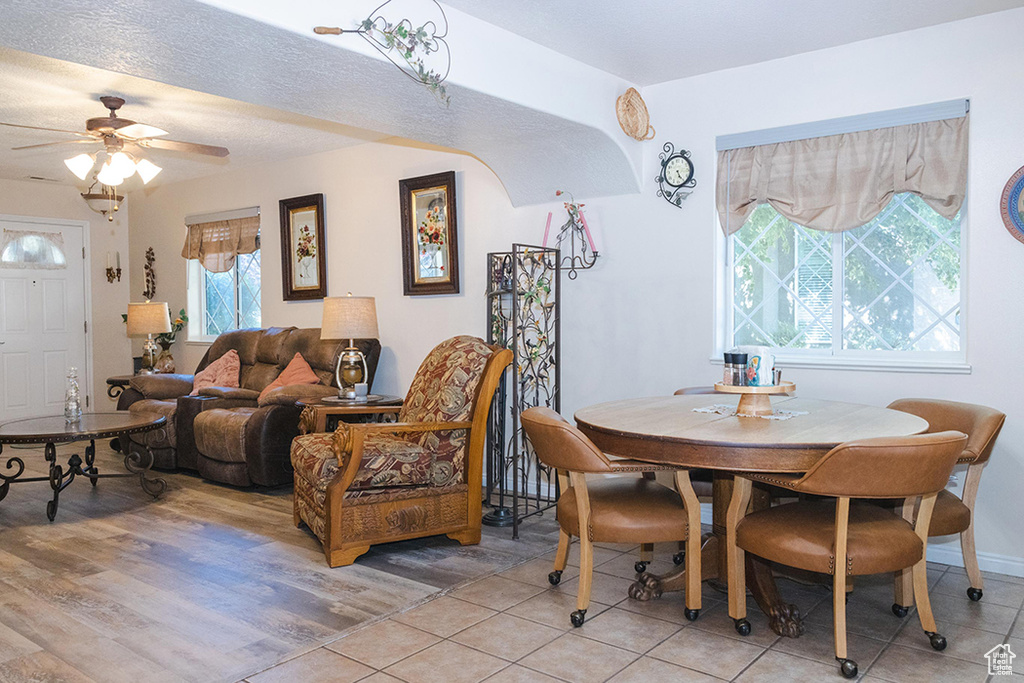 Dining space with a ceiling fan and light tile patterned floors