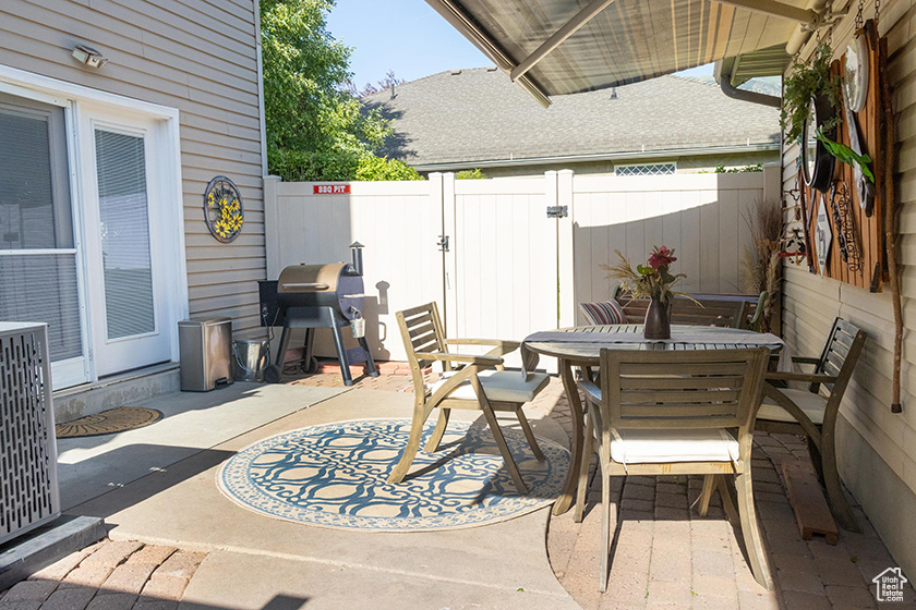 Fenced backyard featuring outdoor dining space, a patio area, and grilling area