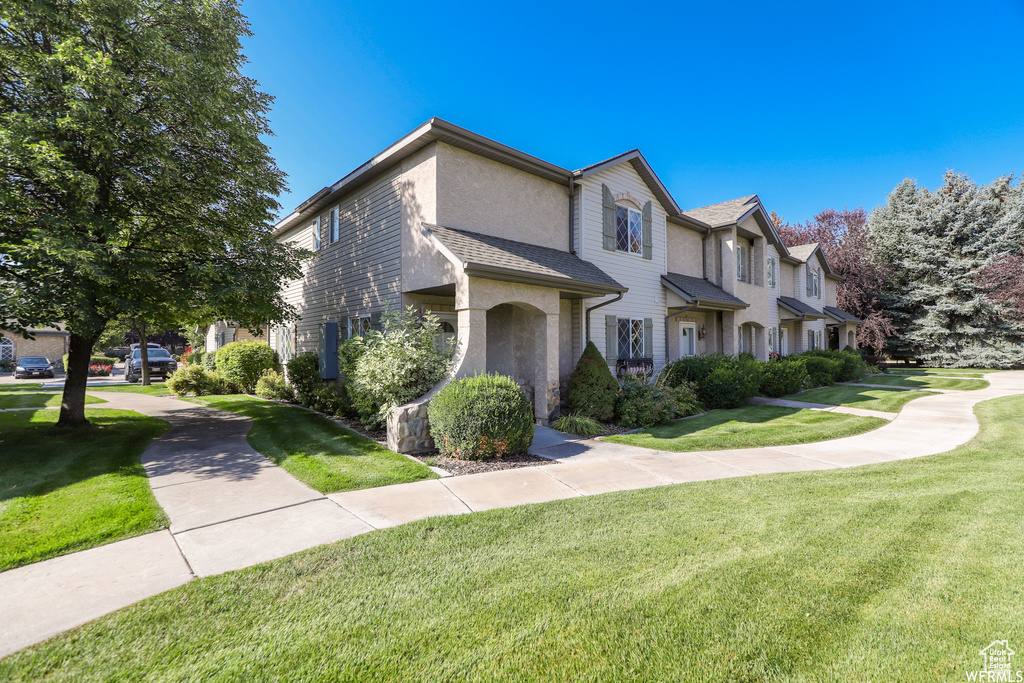 View of front of home featuring a front yard and stucco siding