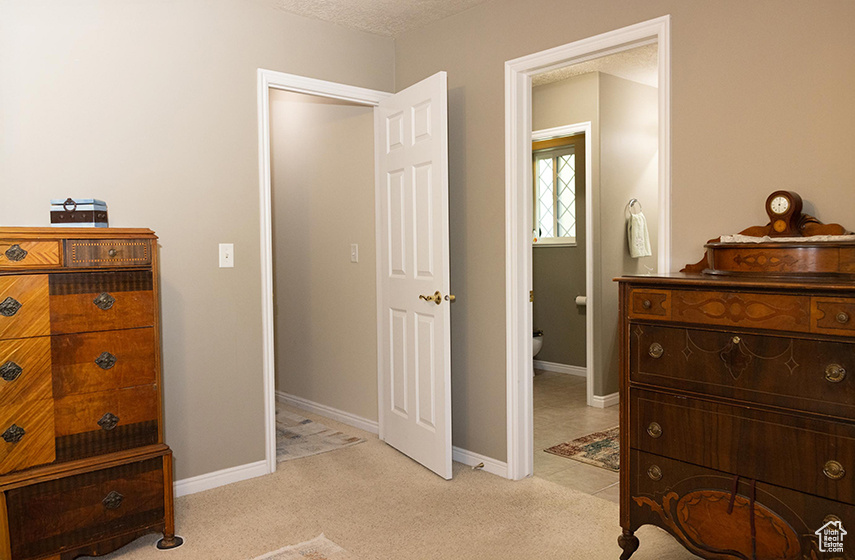 Bedroom with light colored carpet and baseboards