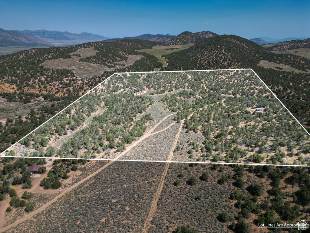 Aerial view of property and surrounding area with property boundaries highlighted and a mountainous background