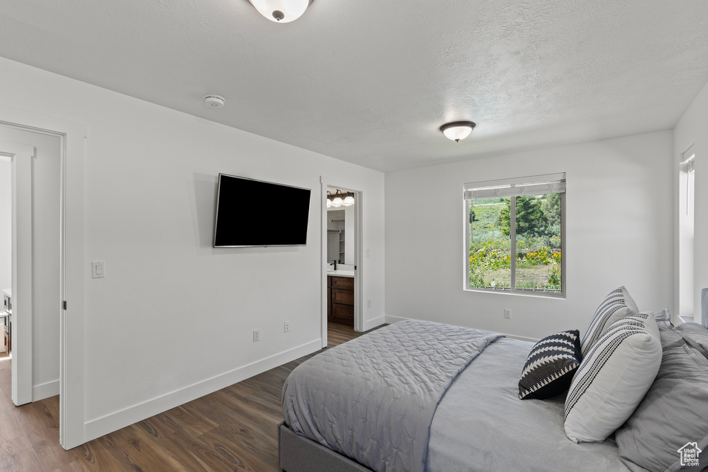 Bedroom featuring dark wood-style flooring and connected bathroom