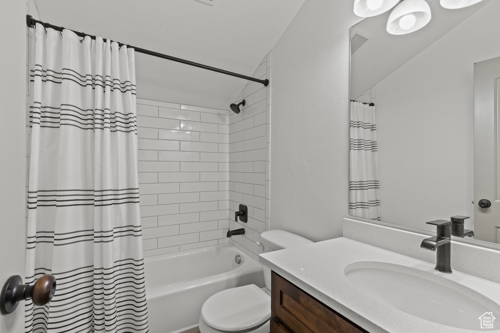 Bathroom featuring vanity and shower / tub combo with curtain