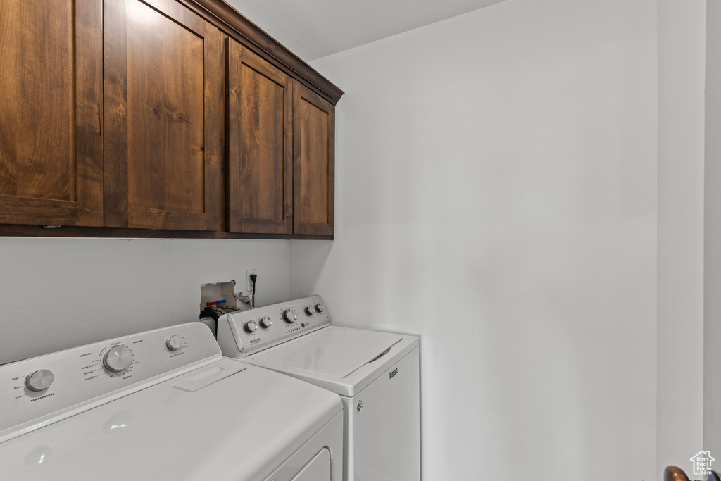 Laundry room with cabinet space and washer and clothes dryer