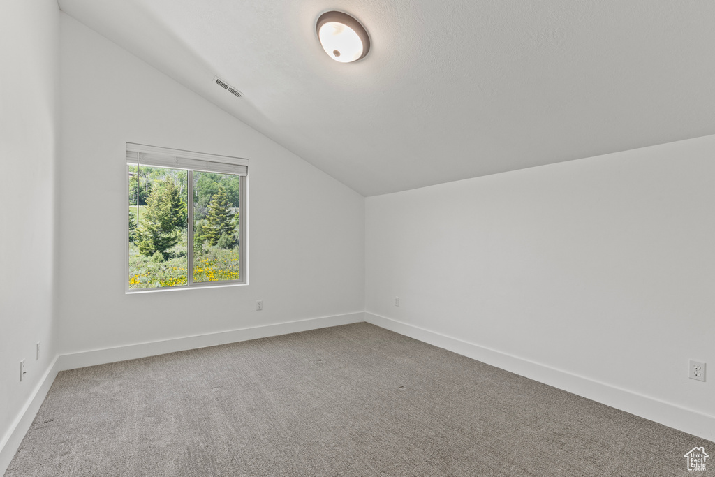 Bonus room with vaulted ceiling and carpet flooring