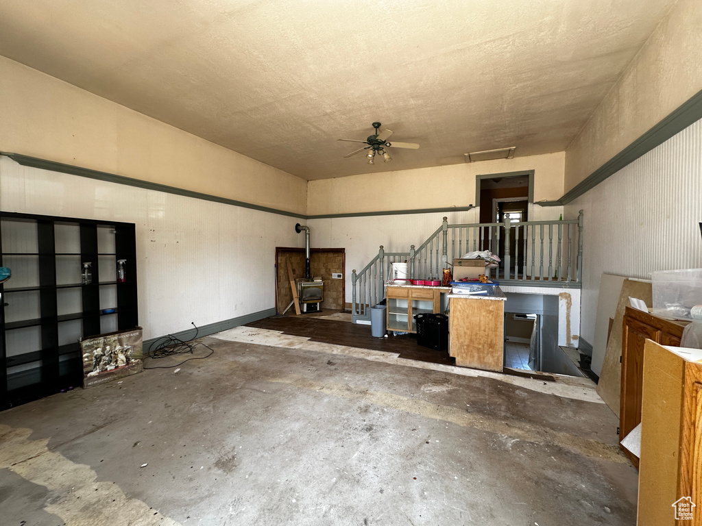 Garage with ceiling fan and a wood stove