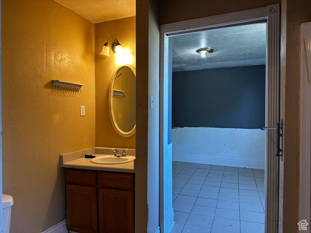 Half bath with vanity and tile patterned floors