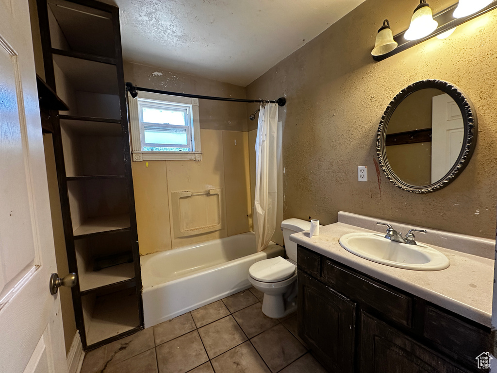 Full bath with tile patterned flooring, shower / bath combo with shower curtain, and vanity